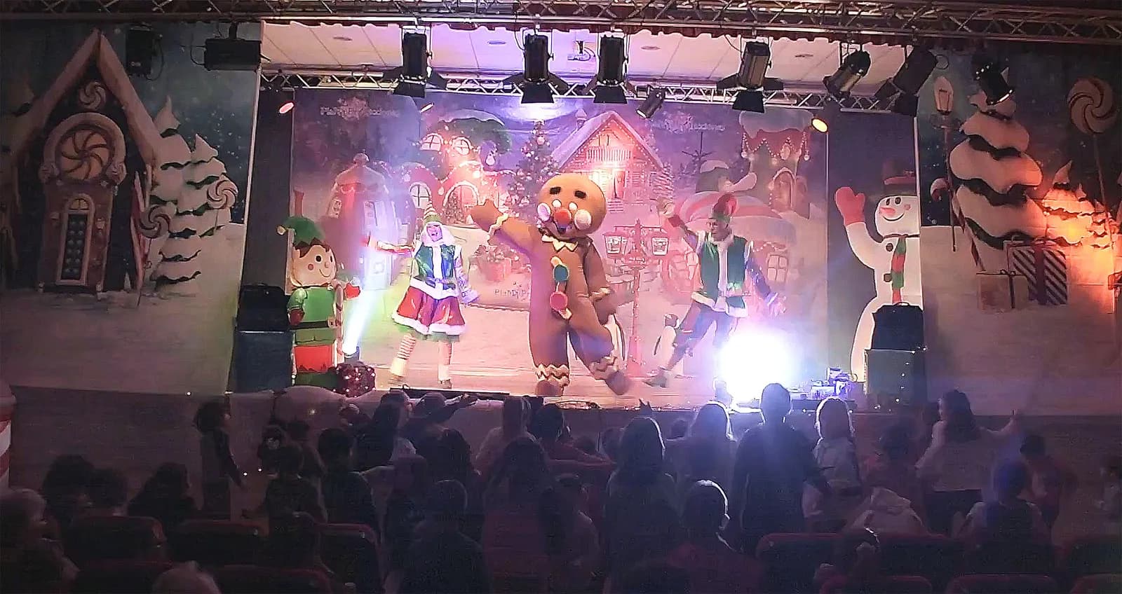 Escenario de Baila la Navidad con muñeco de jengibre y público