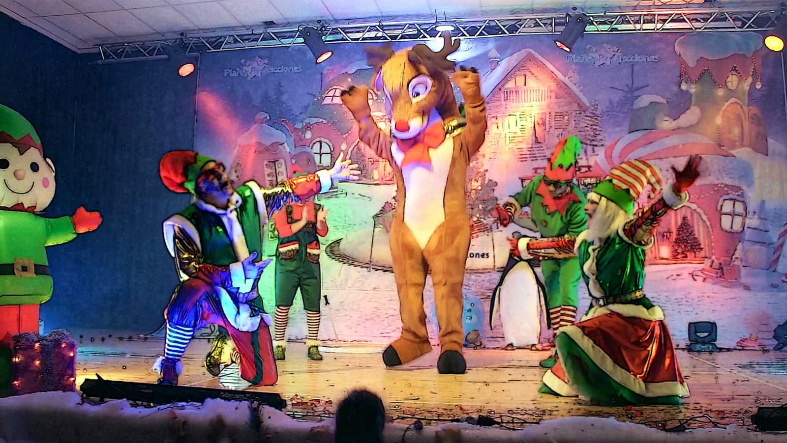 Escenario de Baila la Navidad con reno, elfos y pingüino