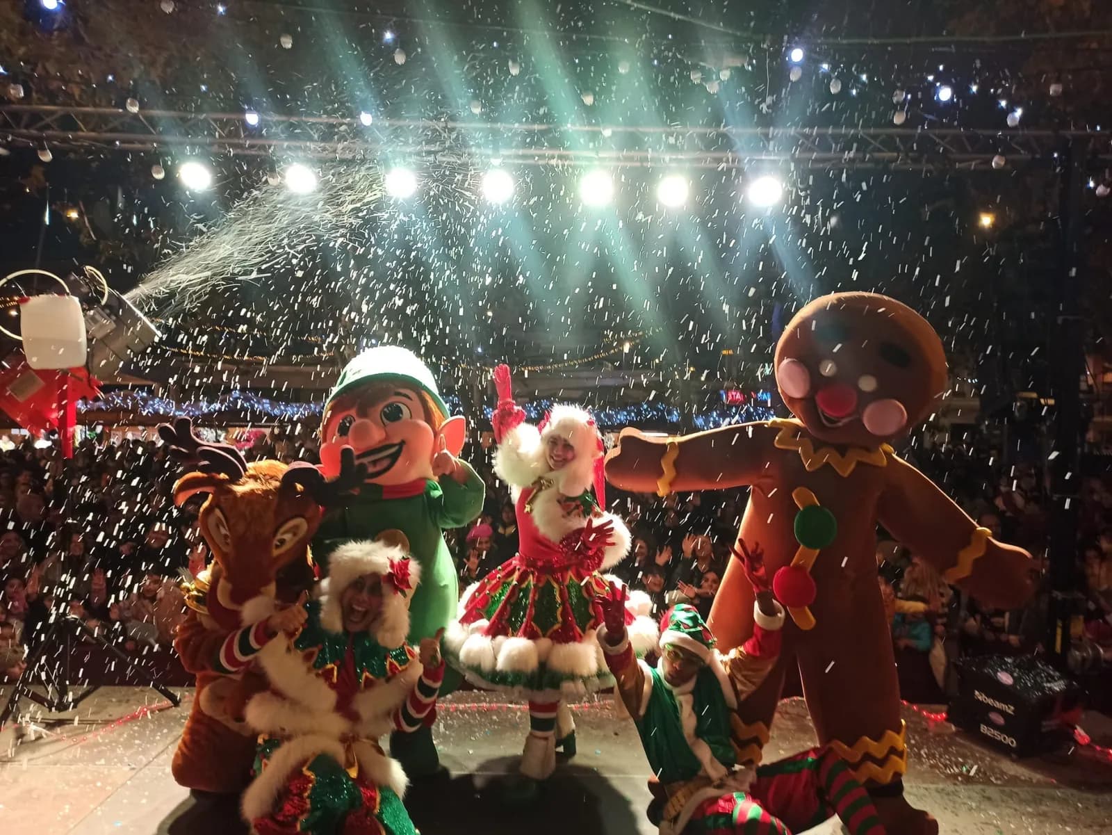 Muñeco de jengibre y elfos en el escenario con nieve