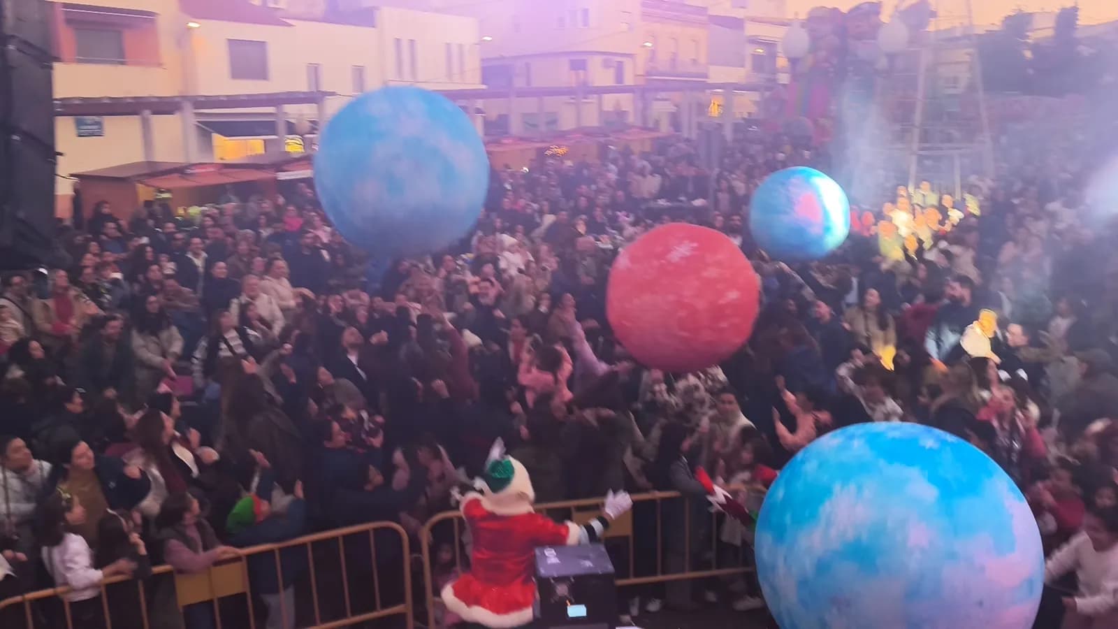 Bolas gigantes azules y rojas sobre una plaza llena de público